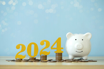 Happy New Year 2024.2024 wooden letter on coins stacked with a piggy bank idea for target business cost and budget planning for the new year. savings.Budget, investment, financial, goal and success.