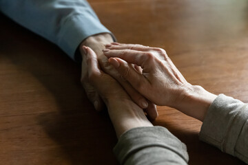Much needed support. Close up view of aged female wife hands caressing palm of elderly male husband friend comforting helping to overcome difficult hard life situation. Two senior people holding hands - Powered by Adobe
