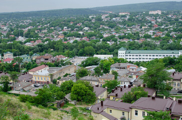 Fototapeta na wymiar view of the city from the hill. top view of the roofs of houses and the road with cars.