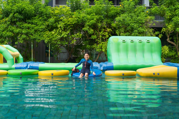 asian child swim or kid girl wearing swimsuit enjoy fun playing adventure water toys to Inflatable...