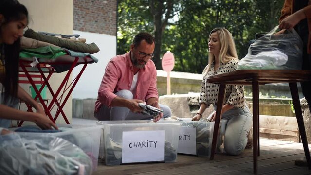 Volunteers sorting of clothes collected in a charity. Charitable work concept.