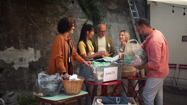 Volunteers sorting of clothes collected in a charity. Charitable work concept.