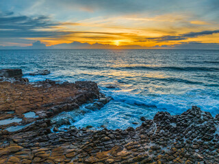 Obraz premium Sunrise over the sea and rock platform with high cloud
