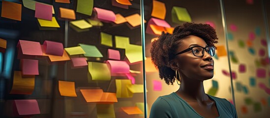 African woman leading team, utilizing sticky notes for business presentation and teamwork collaboration during brainstorming and strategy sessions. - obrazy, fototapety, plakaty