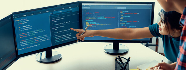 Young Professional website developer and cooperative computer engineer team brainstorming and sharing idea of program writing and coding at modern meeting room. Teamwork concept. Closeup. Burgeoning.