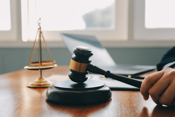 Business and lawyers discussing contract papers with brass scale on desk in office. Law, legal services, advice, justice and law concept picture with film grain effect