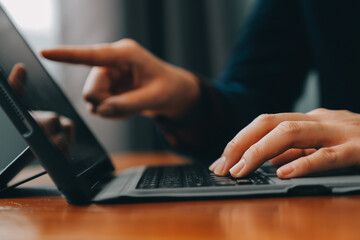Asian Businesswoman Using laptop computer and working at office with calculator document on desk, doing planning analyzing the financial report, business plan investment, finance analysis concept.