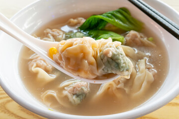 angle view bowl of different style wontons