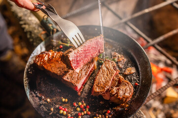 ワイルドに焼くステーキ　Grill a steak over an outdoor - 690872183