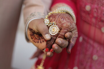 Image of groom holding hand of bride and showing her engagement ring