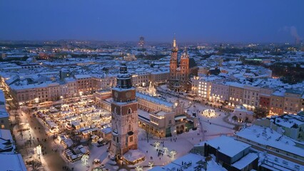 Krakow winter Main Market Square covered with snow aerial drone view of monuments - Saint Mary Church, Sukiennice (Cloth Hall), City Hall Tower, Wawel