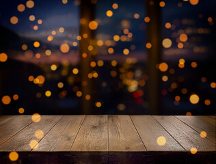 Festive, Christmas, New Year background. Evening. Night. Homely, cozy background. Abstract background. A wooden table on the background of a window with a night view and golden garlands. Bokeh. 