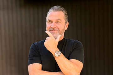 Man wearing a stylish watch and looking friendly to the side