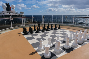 Open outdoor sun deck with large game of chess and figures onboard luxury cruiseship cruise ship...
