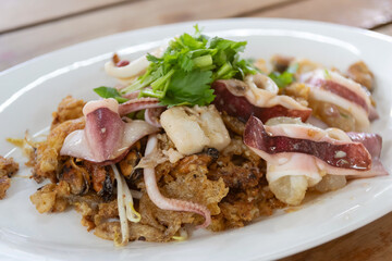 Asian delicious fried  with mussels and octopus with eggs omelette add on bean sprout and mix chili sauce. Popular and delicious street food in Thailand. (Hoy Tod)