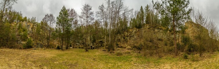 grassy plain in the woods surrounded by rocks panorama