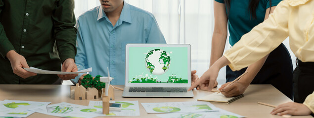 Green city logo displayed on a laptop at a green business meeting. Team presenting green design to...