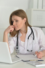 Young sad female doctor working in an office