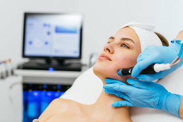 Close-up shot of a young beautiful woman lying on a couch in a cosmetology center. Young woman doing hydrofacial therapy in beauty spa. © wedmoments.stock