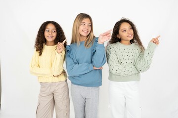 Photo of attractive Three beautiful multiracial kid girls  direct finger empty space cheap dentistry - obrazy, fototapety, plakaty