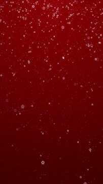 Red Christmas decoration copy space vertical background with falling flickering stars.