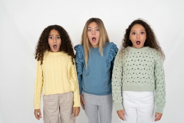 Oh my God. Surprised Three beautiful multiracial kid girls  stares at camera with shocked...