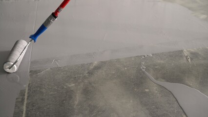 Worker and repair work. Applying an anti-slip layer to the floor of an underground parking lot. A...