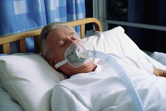 Elderly Man Wearing Oxygen Mask in Bed. Intensive care department in medical facility.