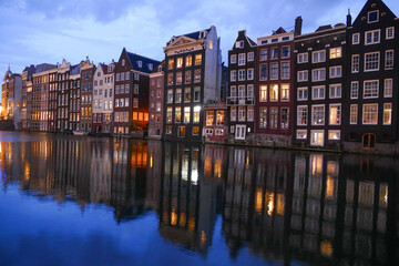Amsterdam tiny houses mirroring in water canal, colourful sunset view, Amsterdam, Netherlands