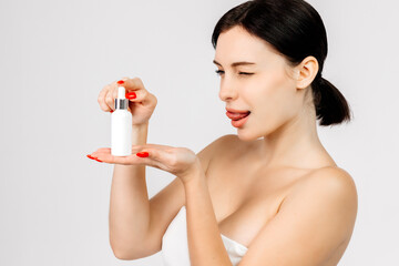 Women's cosmetic procedures. A young attractive, charismatic woman shows a serum or oil for her...