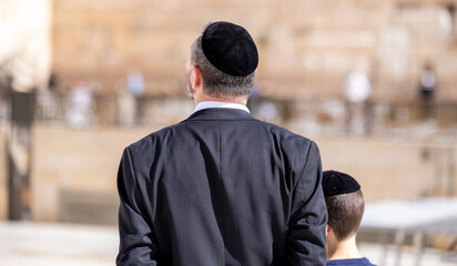 An undefined orthodox Jewish man and his son come to pray at the Western Wall. Jerusalem