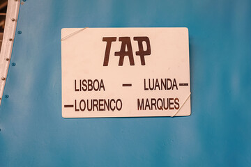 plaque pasted on the fuselage of an airplane with the following words: TAP, Lisbon, Luanda,...