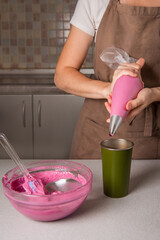 woman cook using of pastry bag for french pastry macaroon. Transfer macaroon batter into piping bag fitted with round tip.