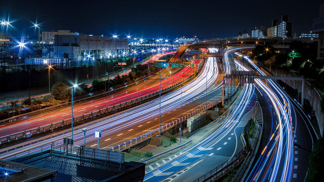 夜の高速道路を走る車の光跡