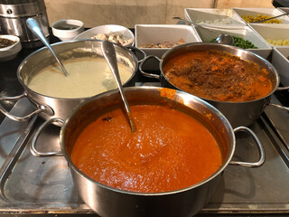 Different pasta sauces simmering on a stove