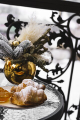 New Year's breakfast on the hotel balcony in the mountains. Coffee with croissant, juice and tangerines against the backdrop of snow-capped mountains. Concept of winter holidays