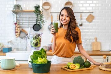 Portrait of beauty healthy asian woman making green vegetables detox cleanse and green fruit smoothie with blender.young girl drinking glass of smoothie, fiber, chlorophyll in kitchen.Diet, healthy. - obrazy, fototapety, plakaty