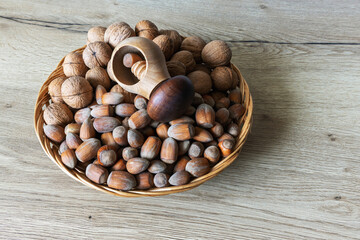 Rustic wooden plate with walnuts and walnuts on an oak table surface