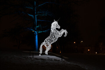 Unicorn made of light in public park at night