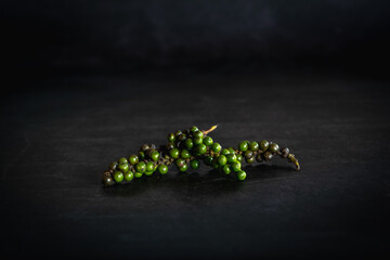 black pepper peppercorns on a dark background