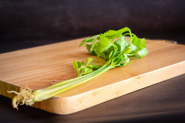 fresh celery on a wooden cutting board
