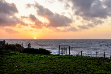 Sunset over sea from a cliff top view