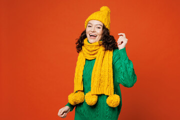 Young vivid happy woman wear green knitted sweater yellow hat scarf dance waving rising have fun...
