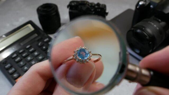 jeweler looking at ring with blue stone tourmaline paraiba, jewerly inspect and verify, pawnshop concept, jewerly shop