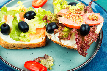 Sandwiches or bruschetta with fish and sausages.