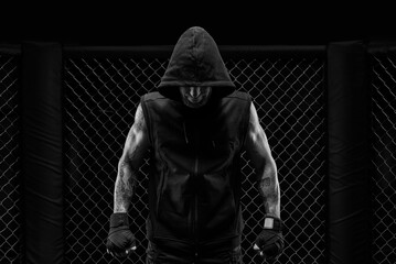 The dramatic black white image of the MMA fighter. Photography in a real octagon. Brutal fighter