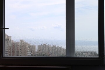 Fototapeta na wymiar Window with water drops on rainy day
