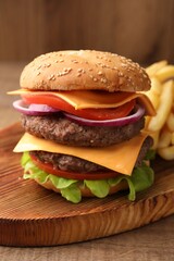 Delicious burger with meat cutlets, cheese, vegetables and lettuce on wooden table, closeup
