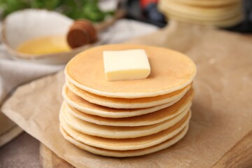 Delicious pancakes with butter on table, closeup