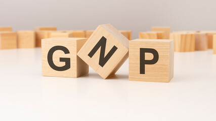 GNP text written on a wooden cubes. can be used for business, marketing, financial concept. selective focus. gray background